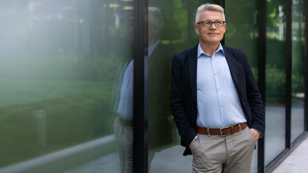 Man in suite next to window photo