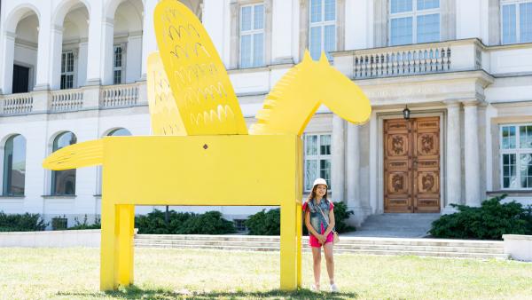 Young girl next to large sculpture photo