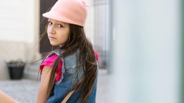 Young girl looking from behind photo