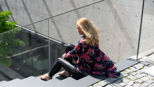 Woman sitting on concrete stairs