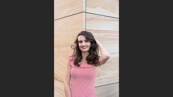 Young woman in front of sandstone wall