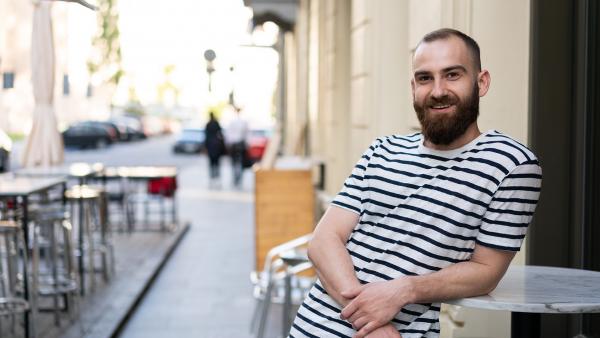 Young man with beard in street cafeteria 