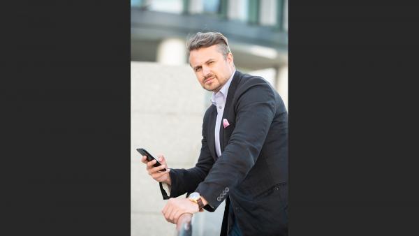 Man with phone in hand on balustrade