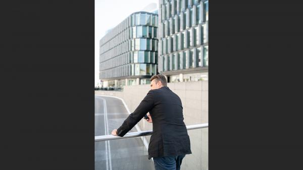 Man leaning on the balustrade in back