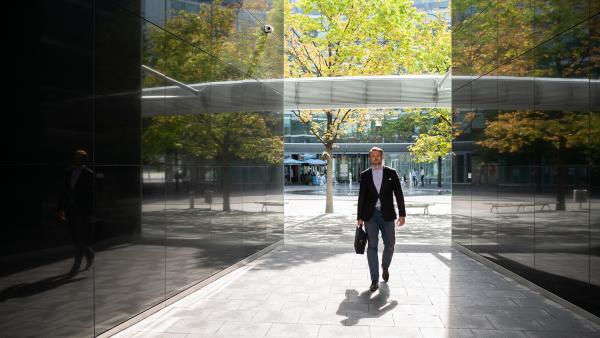 Walking businessman in sunlight