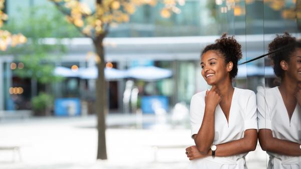 Young woman leans on wall in city center