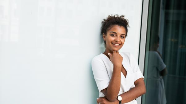 Woman leans on a white wall