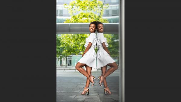 Black woman in white dress with mirror reflection