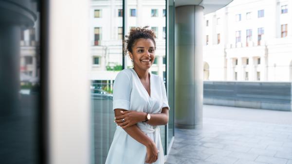 Standing woman next to concrete column