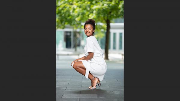 Woman squat next to tree