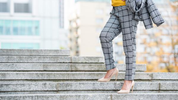 Woman legs in formal trousers at concrete stairs