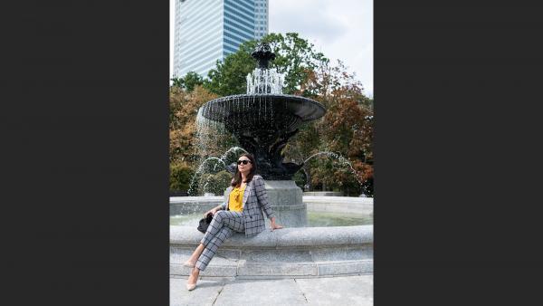 Mature woman on park sitting next to fountain