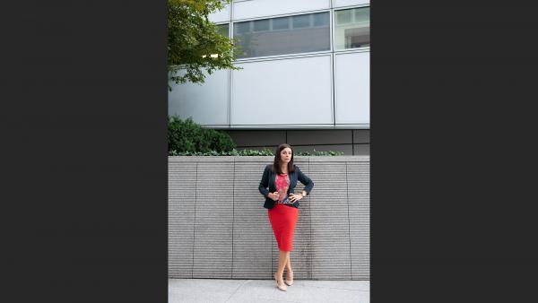 Businesswoman standing next to stone wall