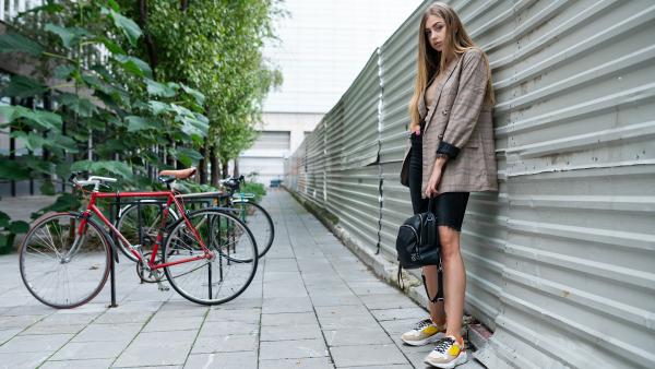 Young woman standing next to bicycles