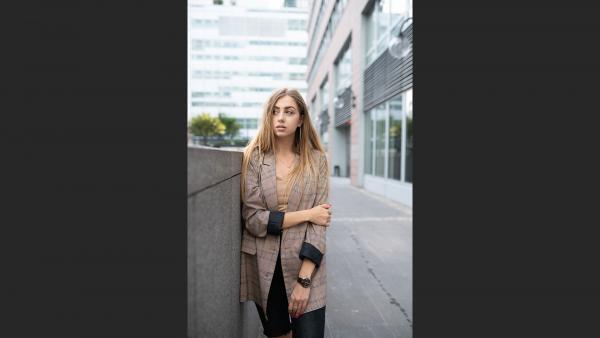 Young corporate working girl next to concrete wall