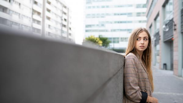 Blonde girl leans to wall