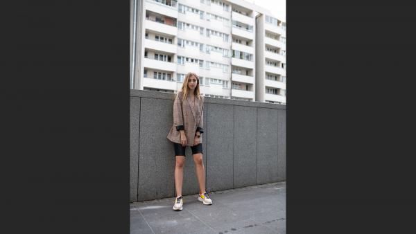 Young woman next to block of flats