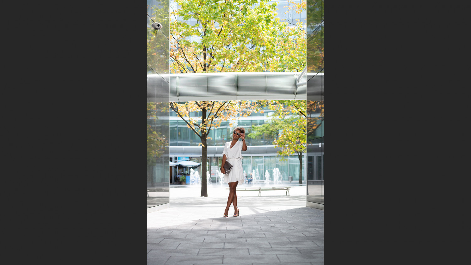 Woman standing on concrete floor next to green tree image