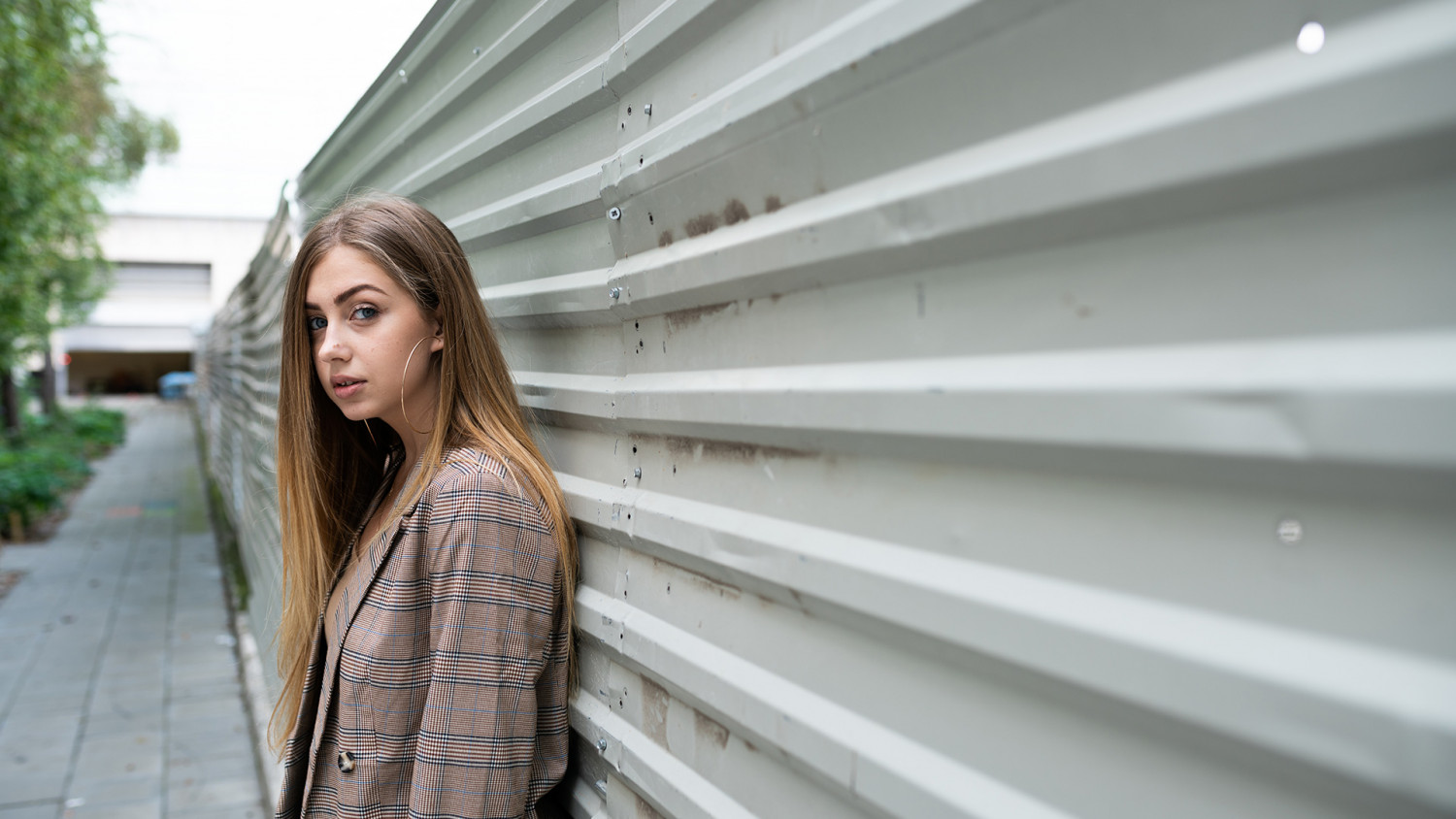 Teenager leans against a sheet metal wall image